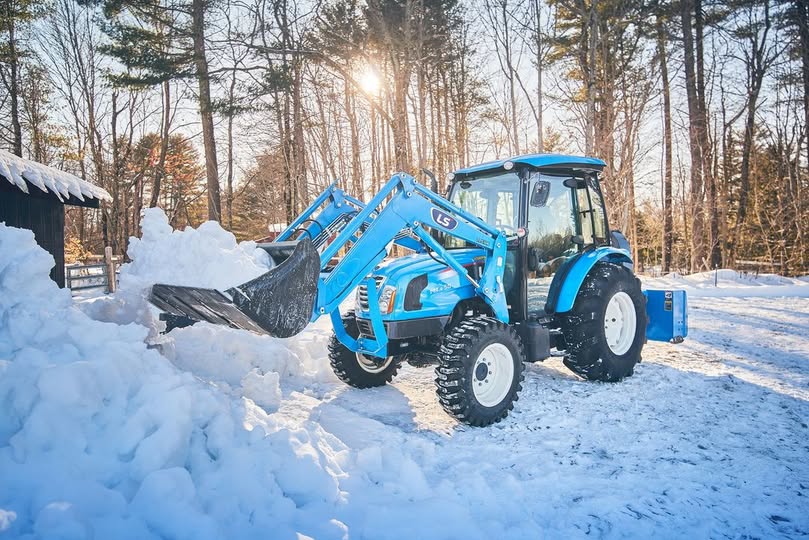 A tractor moving snow in the winter